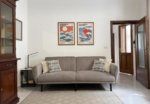 a living room with a couch and two posters on the wall at Casa Lia - Independent apartment in the Gulf of Orosei in Galtellì