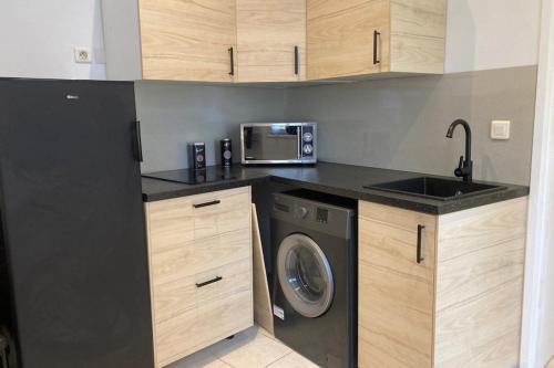 une cuisine avec un lave-linge et un micro-ondes dans l'établissement Beautiful 1-bedroom apartment - near the beach, à Cannes