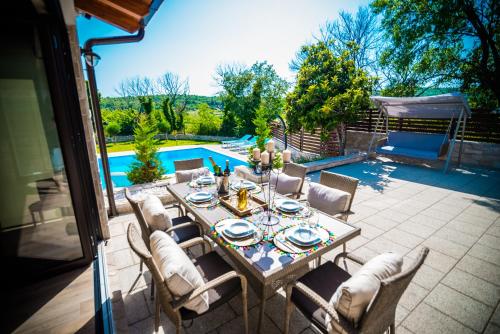 a patio with a table and chairs next to a pool at Villa Tia in Mostar