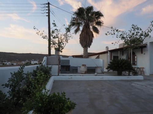 una villa con una palma e una casa di Orchid 3 Bedroom Suite Kastraki a Kastraki