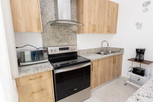 a kitchen with a stove and a sink at Ka' Romana Residences in El Soco