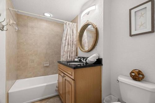 Un baño con lavabo, bañera y espejo. en Centrally Located 3-Bed I Walk Everywhere, en Clearwater Beach