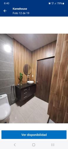 a bathroom with a toilet and a sink and a mirror at Kame House in Chitré