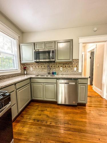 a kitchen with stainless steel appliances and wooden floors at The Red House Albany NY 4 Bedroom Private Apartment in Albany