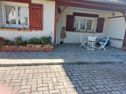 a patio of a house with a table and chairs at la picarde in Tours-en-Vimeu