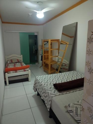 a room with two beds and a room with shelves at Aconchego da Kika in Caruaru