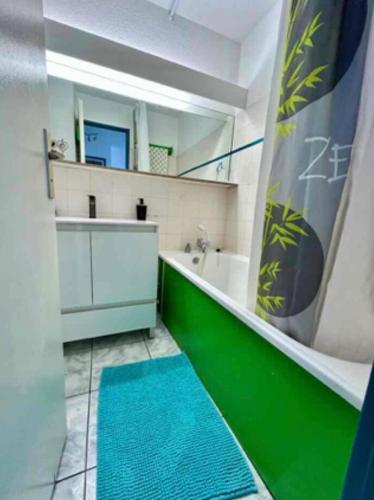 La salle de bains est pourvue d'une baignoire et d'un tapis bleu. dans l'établissement Lake view apartment with pool, au Barcarès