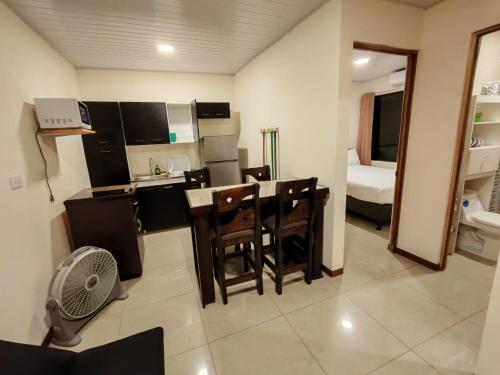 a kitchen with a table and chairs in a room at Bandera Beach Cabins in Parrita