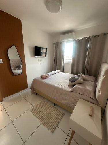 a small bedroom with a bed and a mirror at Flor da Amazônia Cop30 Belém-Pa in Ananindeua