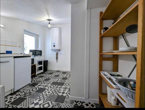 eine Küche mit schwarz-weißem Fliesenboden in der Unterkunft Le calme in Saint-Brieuc