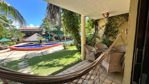 a hammock on a porch with a view of a pool at Solar de Pipa Prime - Frente piscina in Pipa