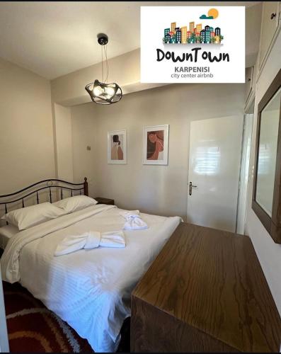 a bedroom with a bed with two towels on it at Down Town Karpenhsi in Karpenisi