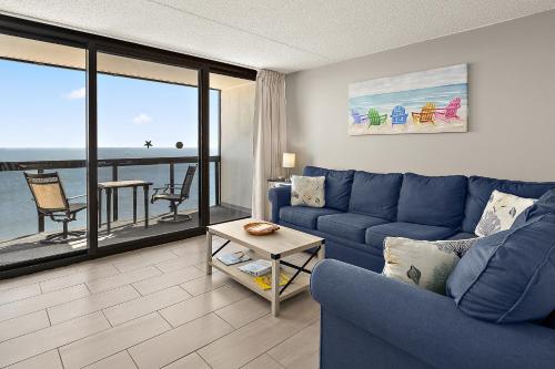 - un salon avec un canapé bleu et une vue sur l'océan dans l'établissement GS 2008 - Seaside Haven, à Ocean City