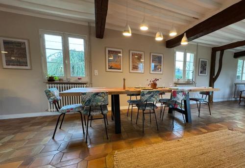 une salle à manger avec une grande table et des chaises en bois dans l'établissement L'Acanthe, Family home in Baie de Somme, à Lamotte-Buleux
