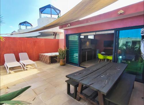 a patio with a wooden table and chairs at Panacea Condo Tulum in Tulum