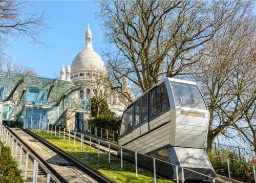 un bâtiment avec un bus devant lui dans l'établissement Charmant studio au pied de Montmartre dans résidence avec gardien et caméra de surveillance, à Paris