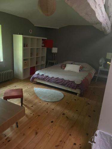 une chambre avec un lit et un parquet dans l'établissement Maison Atypique dans le Gers avec activités, à Pavie