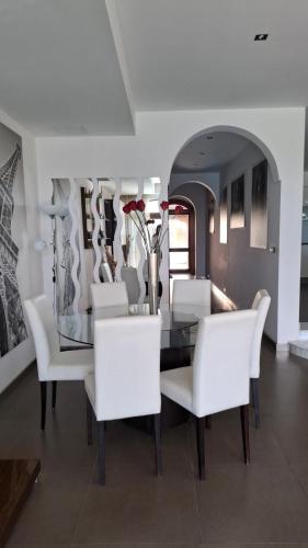 a dining room with a table and white chairs at Aurelia Gozo Boutique BnB in Xagħra
