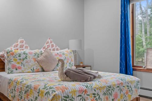 a bedroom with a bed with a stuffed swan on it at Spacious Game Room Seclusion Hot Tub and more in Long Pond