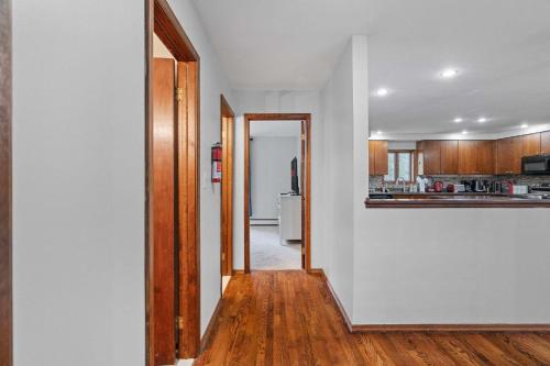 a kitchen with white walls and a hallway with wooden floors at Spacious Game Room Seclusion Hot Tub and more in Long Pond