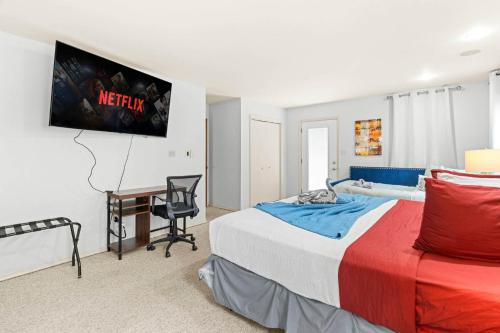 a bedroom with a bed and a desk and a tv at Spacious Game Room Seclusion Hot Tub and more in Long Pond
