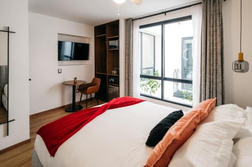a bedroom with a bed with a large window at Casa Castillo Condesa in Mexico City