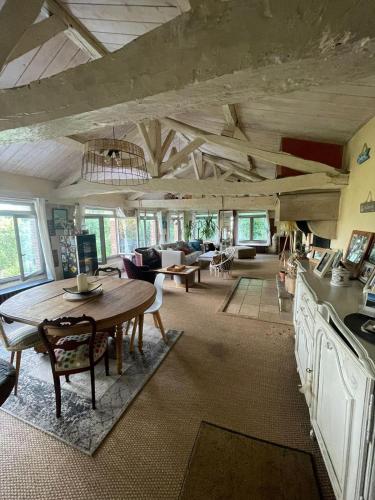 un grand salon avec une table et des chaises dans l'établissement Maison Atypique dans le Gers avec activités, à Pavie