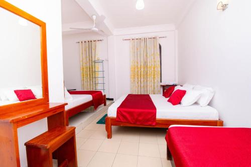 a hotel room with two beds and a mirror at Colour Moon Hotel in Kotagala