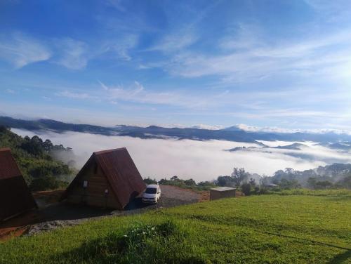 a car parked next to a small building on a field at Montanha Home in Monte Verde