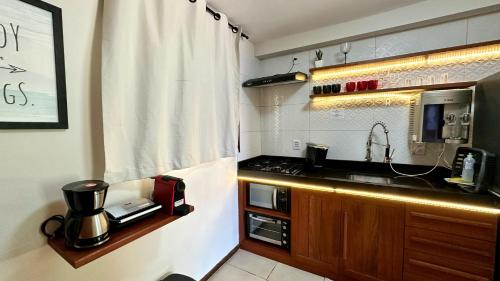 a small kitchen with a sink and a microwave at Solar de Pipa Prime - Frente piscina in Pipa