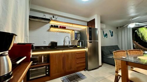 a kitchen with a stainless steel refrigerator and a couch at Solar de Pipa Prime - Frente piscina in Pipa