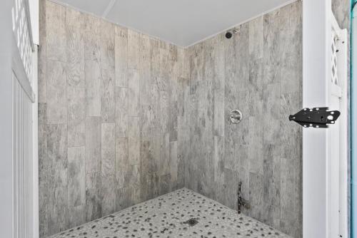 a bathroom with a shower with a tiled wall at The Blue River House in Fort Myers