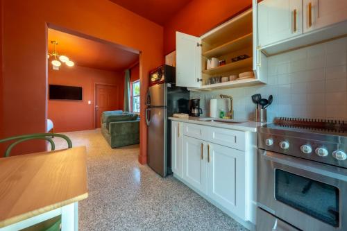 a kitchen with orange walls and white cabinets and an oven at Monaco Vacation Rentals in Clearwater Beach