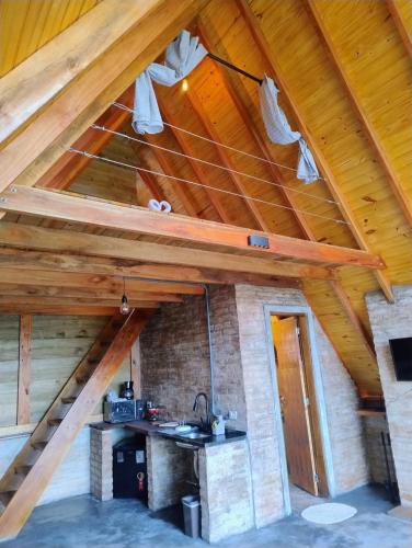 a kitchen in a house with wooden ceilings at Montanha Home in Monte Verde