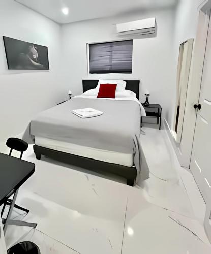 a white bedroom with a large bed and a desk at Cute Private Room - Close to airport & Free parking 01 in Miami