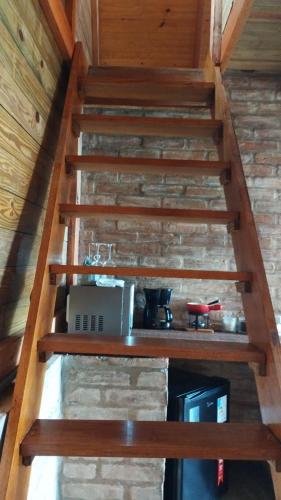 a set of stairs in a cabin with a kitchen at Montanha Home in Monte Verde