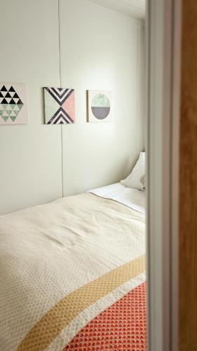 a small bedroom with a bed and some pictures on the wall at Greta Hillside in Buceş-Vulcan