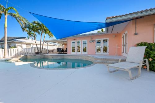 a patio with a chair and a swimming pool at Whispering Palms! Private canal side dock and pool with spa! in Bradenton