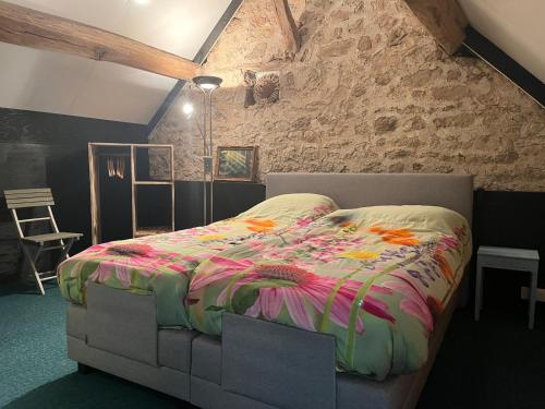 a bed in a room with a stone wall at The Place to Be in Lormes