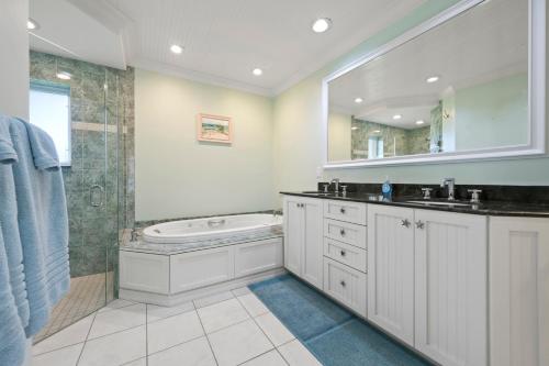 a bathroom with a tub and a sink and a shower at Whispering Palms! Private canal side dock and pool with spa! in Bradenton