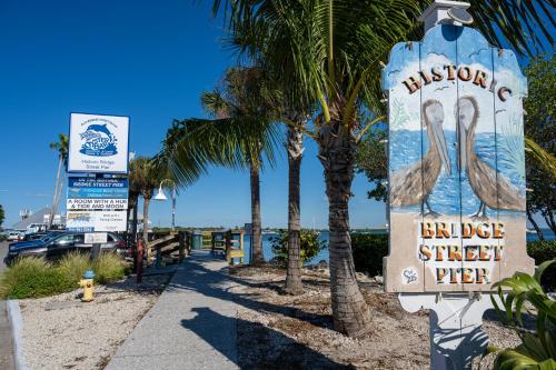 a sign for a bicheno bridge street pier with palm trees at Whispering Palms! Private canal side dock and pool with spa! in Bradenton