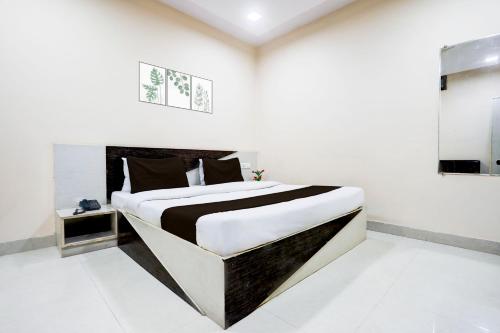 a bedroom with a large bed in a white room at SPOT ON Hotel Swarat in Satna