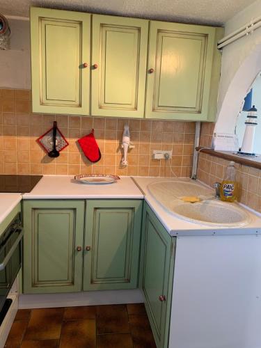 une cuisine avec des placards verts et 2 lavabos dans l'établissement Havre de paix proche de la plage classé 2 étoiles, à Vic-la-Gardiole