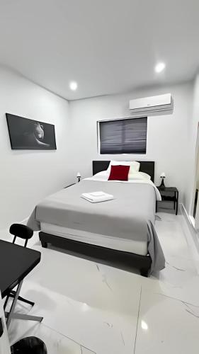 a white bedroom with a large bed with red pillows at Cozy Private Room, near the Airport - Free parking - 01 in Miami
