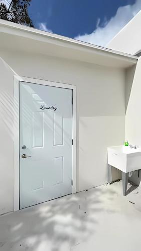a white garage with a door and a table at Cozy Private Room, near the Airport - Free parking - 01 in Miami