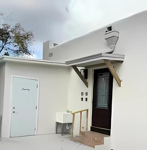 a white house with a black door and a door istg istg at Cozy Private Room, near the Airport - Free parking - 01 in Miami