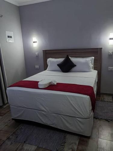 a bedroom with a large bed with two towels on it at The Hornbill Lodge in Nata