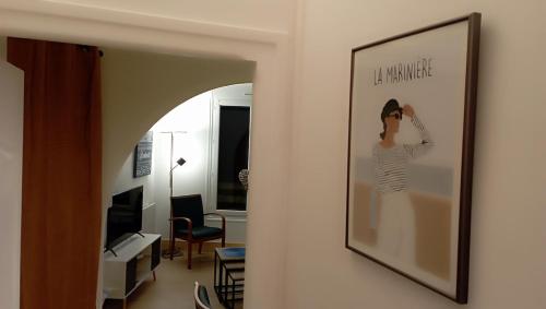 einen Spiegel, der an einer Wand im Wohnzimmer hängt in der Unterkunft La Marinière, appartement avec garage, 2 étoiles à 100m de la mer in Barneville-Carteret