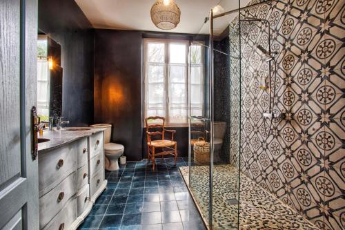 La salle de bains est pourvue d'une douche, de toilettes et d'une chaise. dans l'établissement Villa 1880 & Belle demeure - Centre ville, Jardin Botanique, à Cabourg