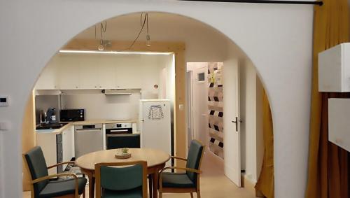 une cuisine et une salle à manger avec une table et des chaises dans l'établissement La Marinière, appartement avec garage, 2 étoiles à 100m de la mer, à Barneville-Carteret